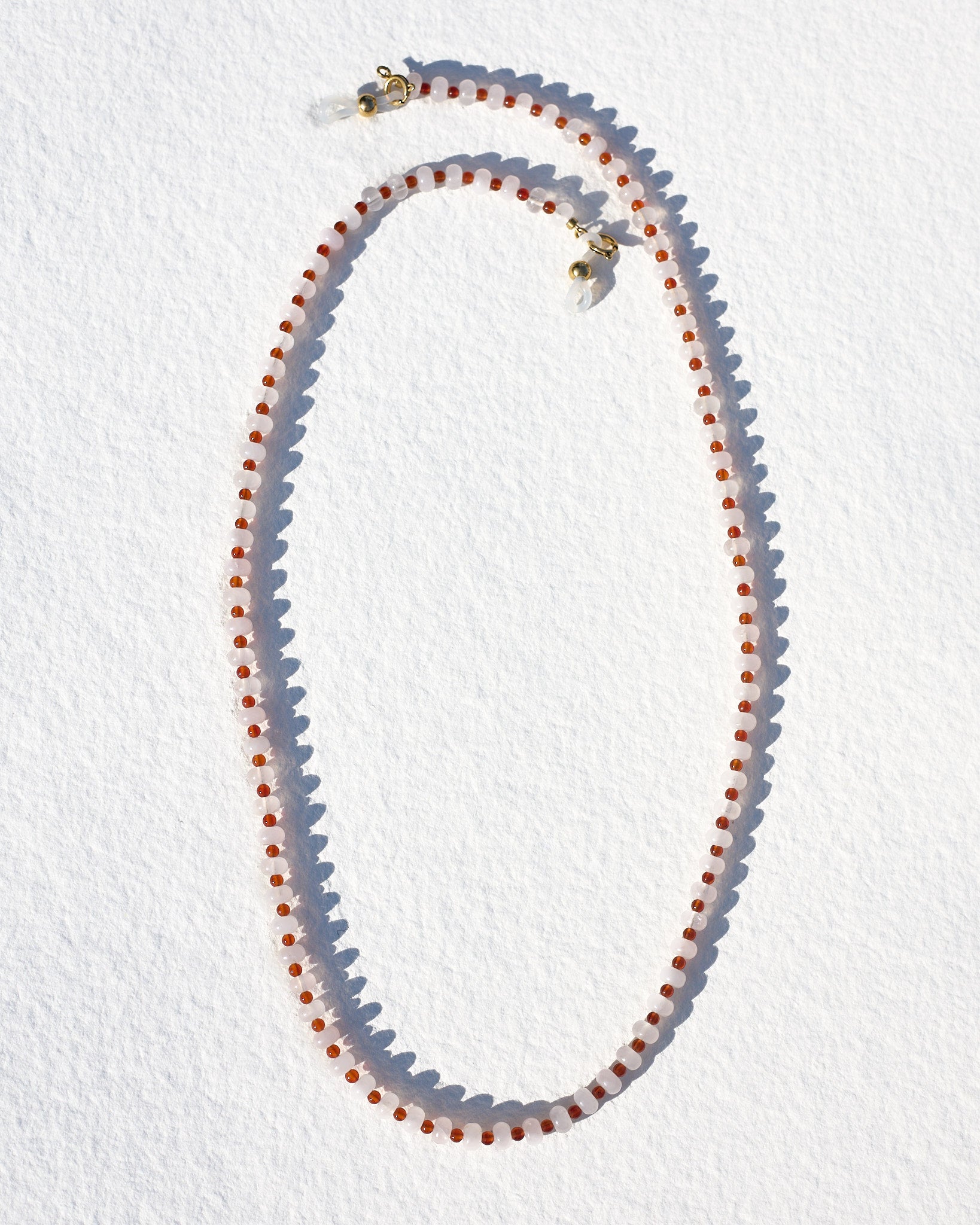 Necklace with red and white beads on a white background