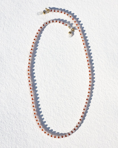 Necklace with red and white beads on a white background